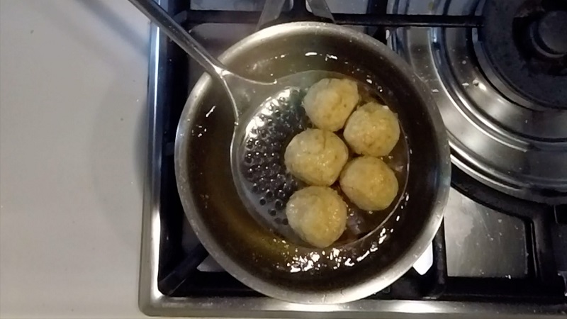 drain the fried mozzarella balls from the oil with a perforated spoon