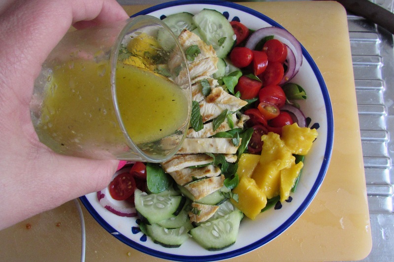 seasoning the mango chicken salad with honey mustard dressing