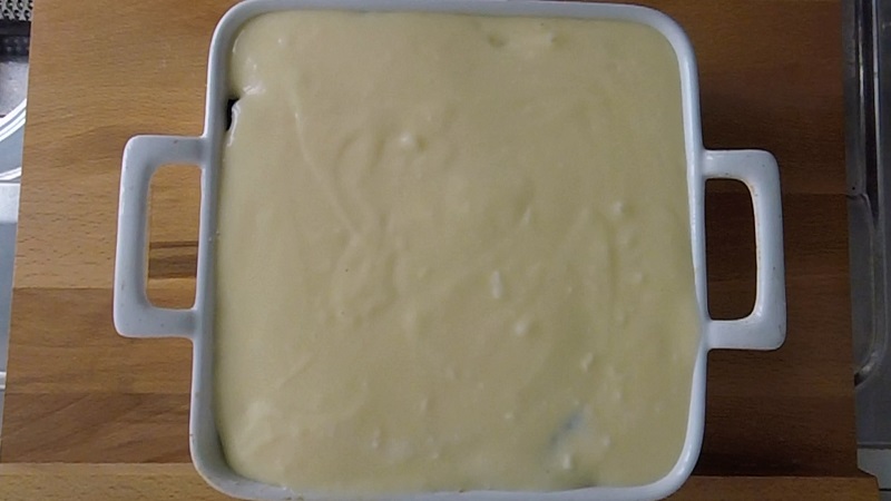 pour bechamel on top of the authentic greek moussaka