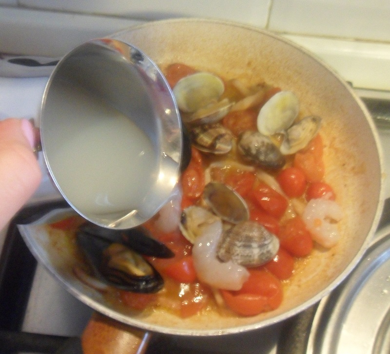 add shrimp, mussels and clams to the sauce of the seafood linguini pasta
