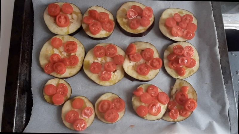 put the cherry tomatoes on the aubergine slices for mini eggplant pizzas
