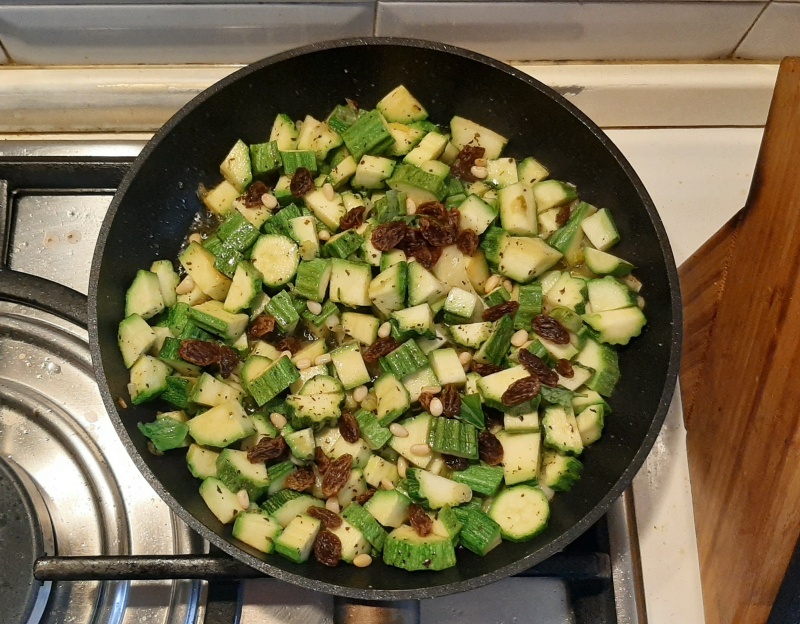 add the zucchini, raisins and pine nuts in to the pan for the caponata