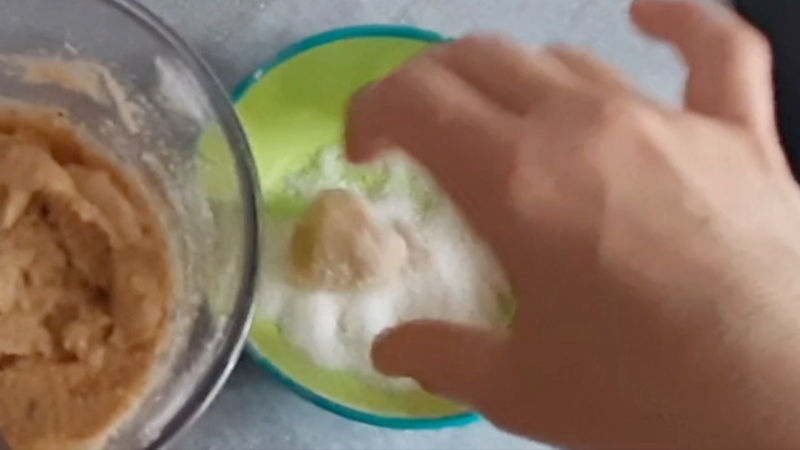 roll the dough balls in granulated sugar